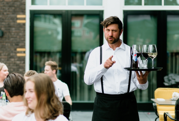 Gedreven horecamedewerker Pepijn serveert verschillende glazen op de juiste manier dankzij Apprendo.